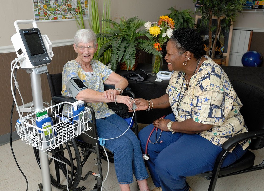A nurse assists a resident with health monitoring.