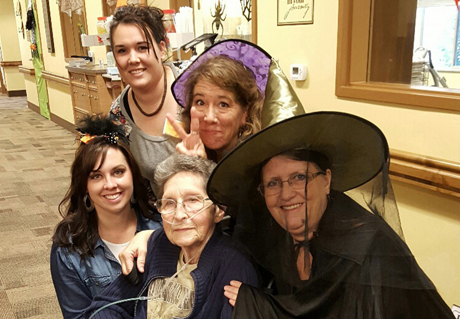 Four staff members and a resident in Halloween costumes.