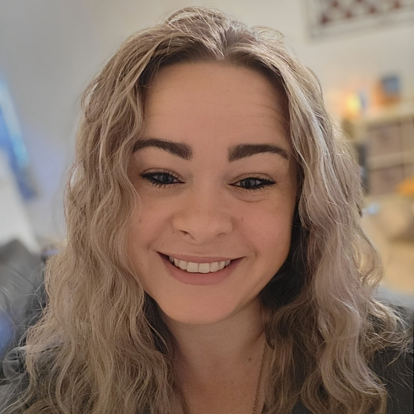 Smiling staff member in an indoor setting.
