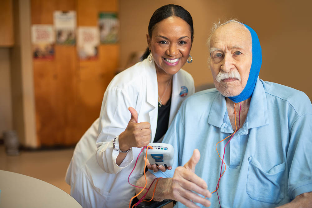 A nurse and resident smiling in a care facility