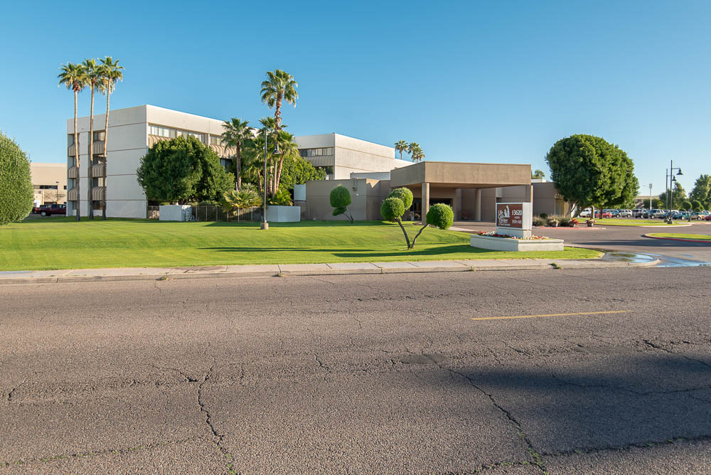 Exterior view of Life Care Center of North Glendale with palm trees