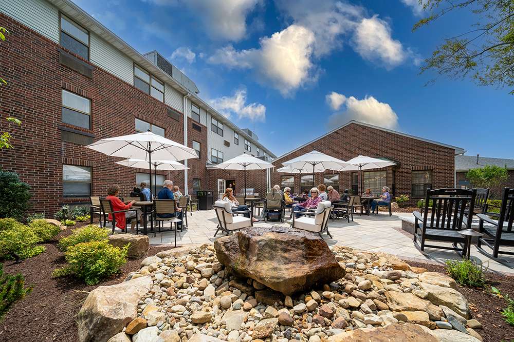 Residents enjoying the outdoor patio area with umbrellas