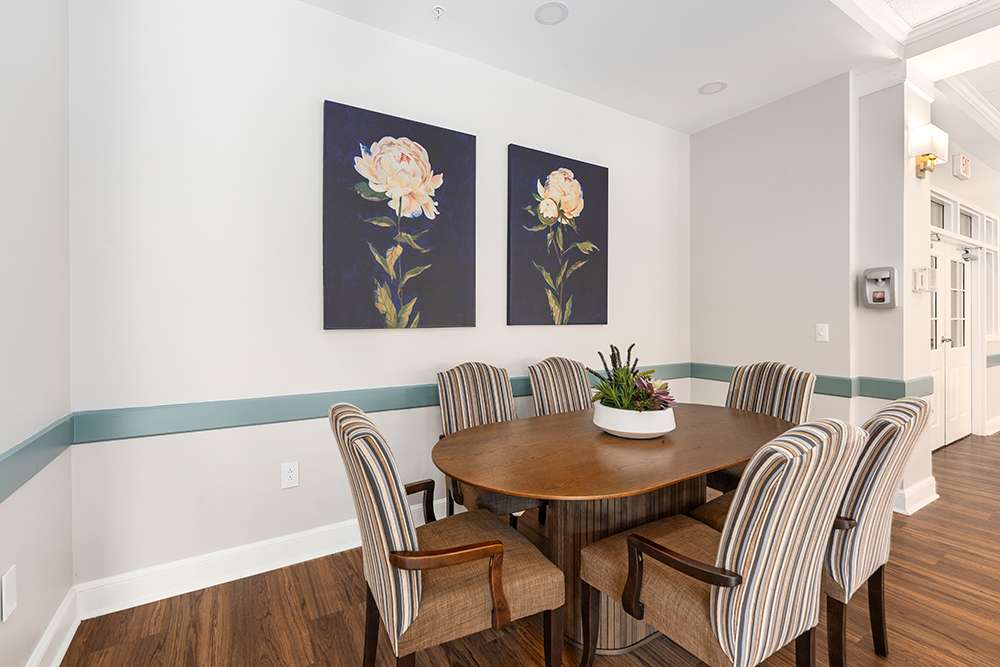 Bright common area with a circular table and floral artwork