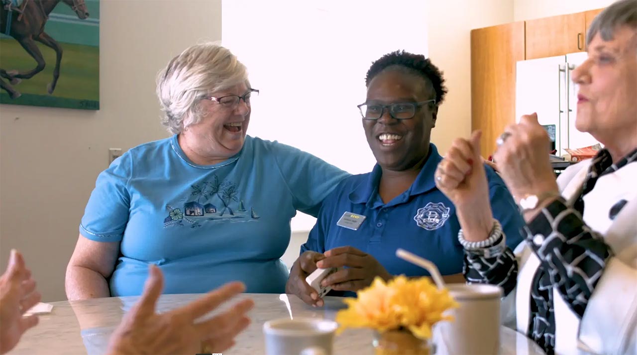 Residents and staff sharing a joyful moment in a common area