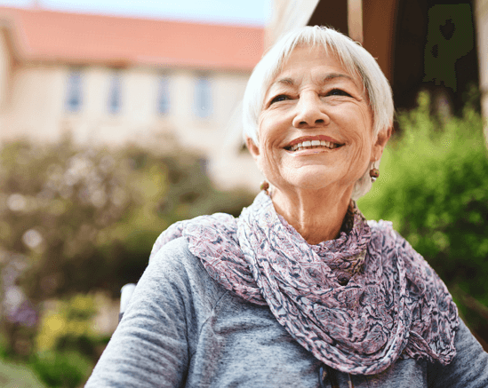 Smiling elderly woman outside in a garden