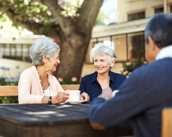 Two elderly women enjoying tea outdoors