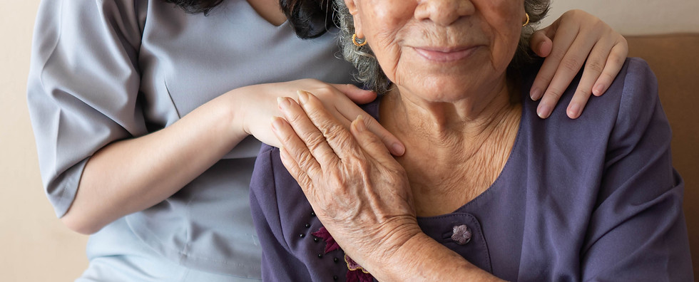 A senior resident and caregiver smiling together