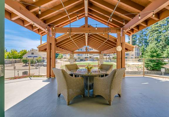Outdoor seating area with tables and chairs under a gazebo