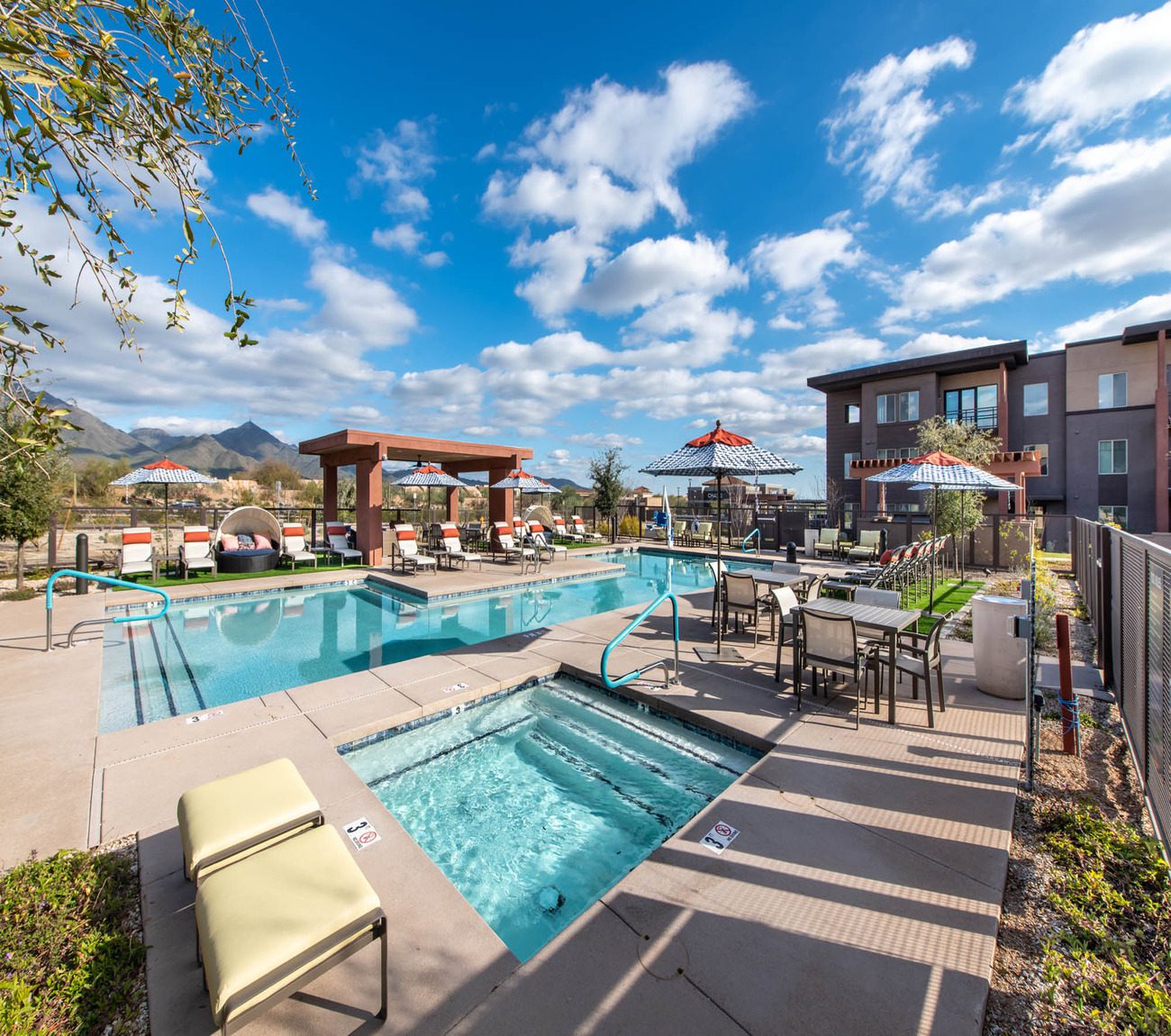 Outdoor pool area with lounge chairs and umbrellas