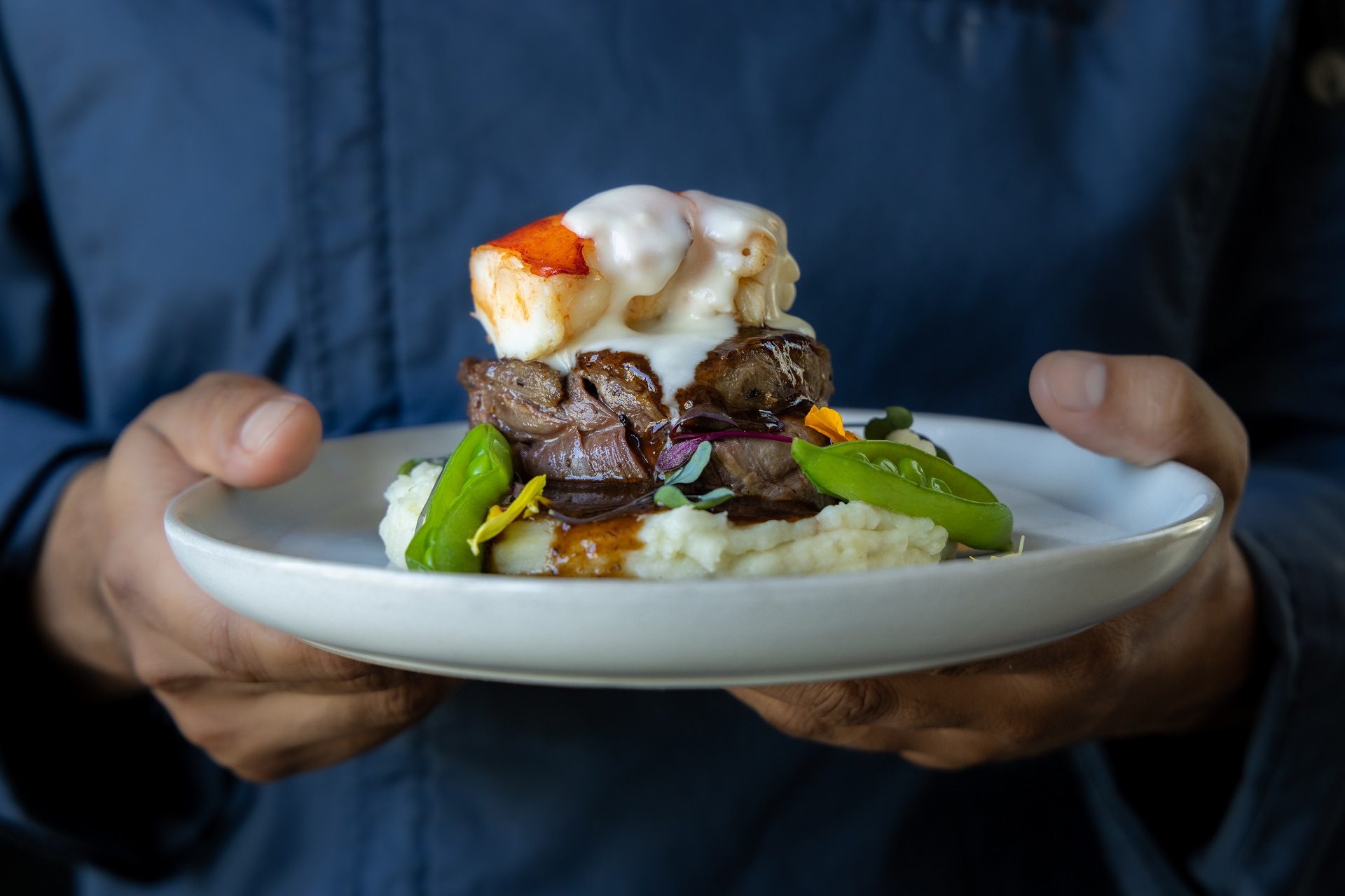 A chef presenting a gourmet plate of food
