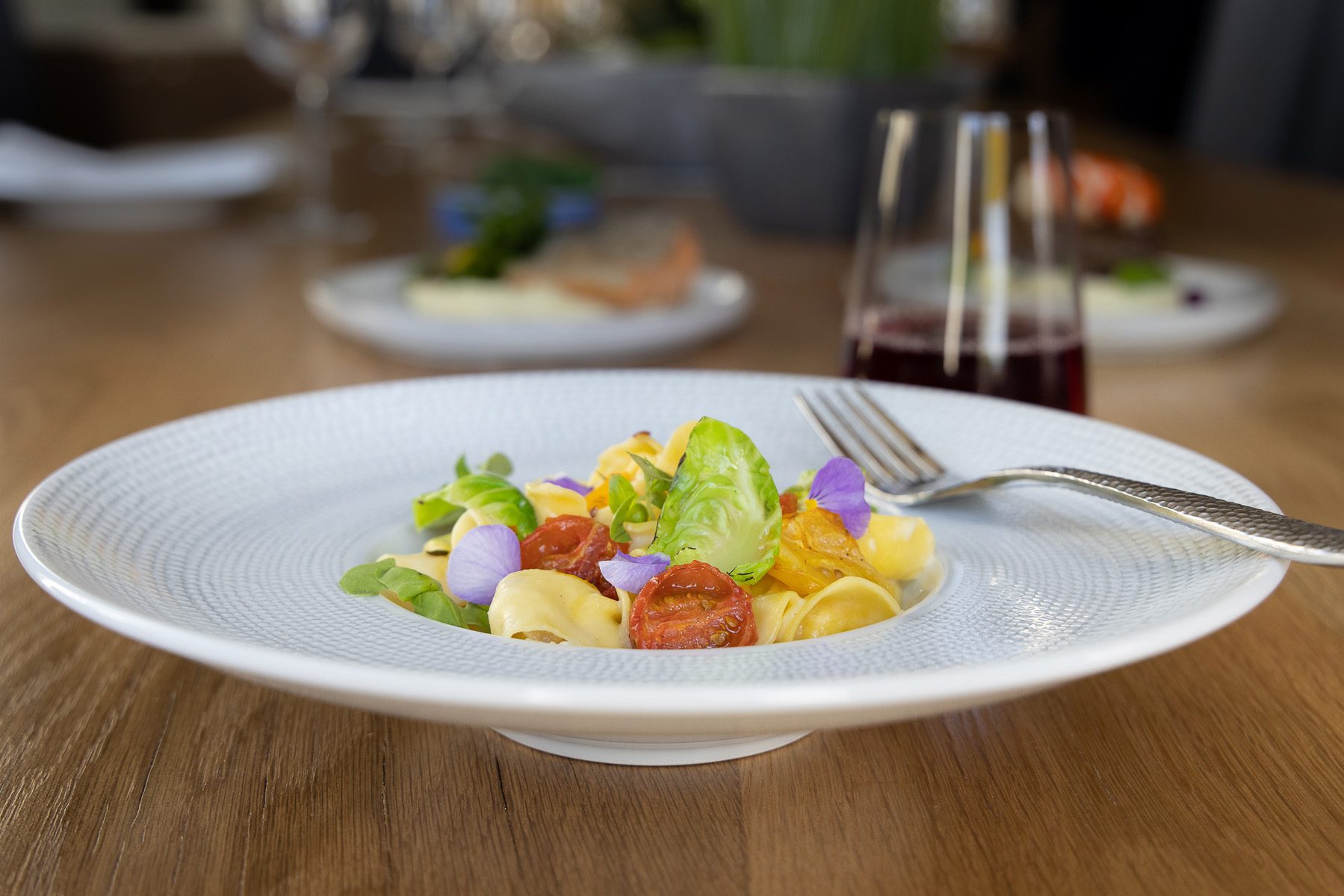 Plate of gourmet pasta with vegetables and garnish