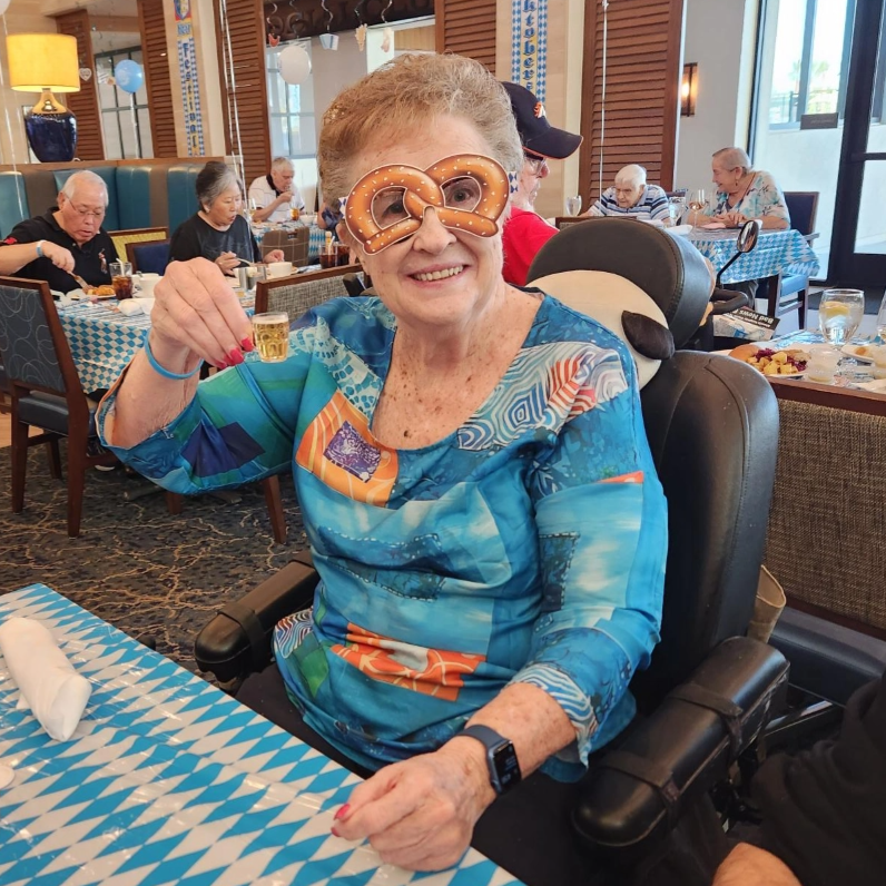 Resident enjoying a festive meal with oversized glasses