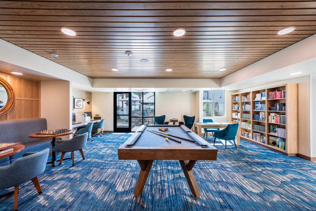 Bright common area with a pool table and bookshelves