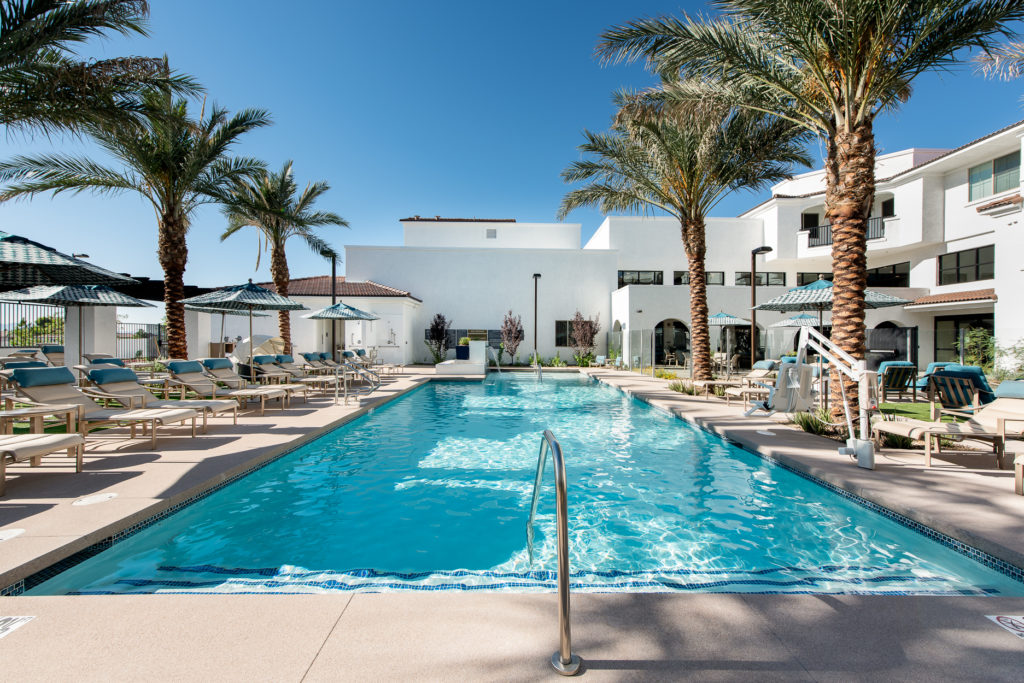 A sunny pool area surrounded by palm trees