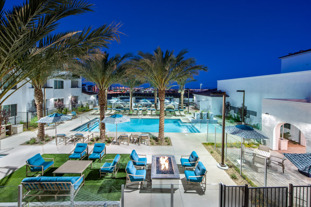 Outdoor pool area with lounge chairs and palm trees