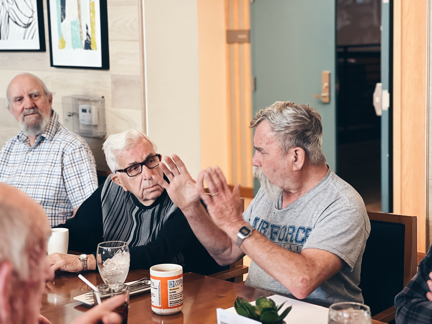 Seniors engaged in conversation at a dining table
