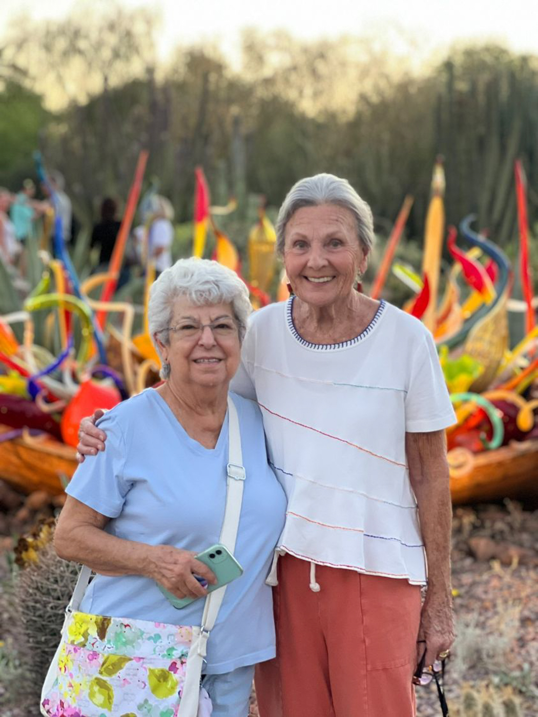 Two residents posing happily outdoors with colorful art.