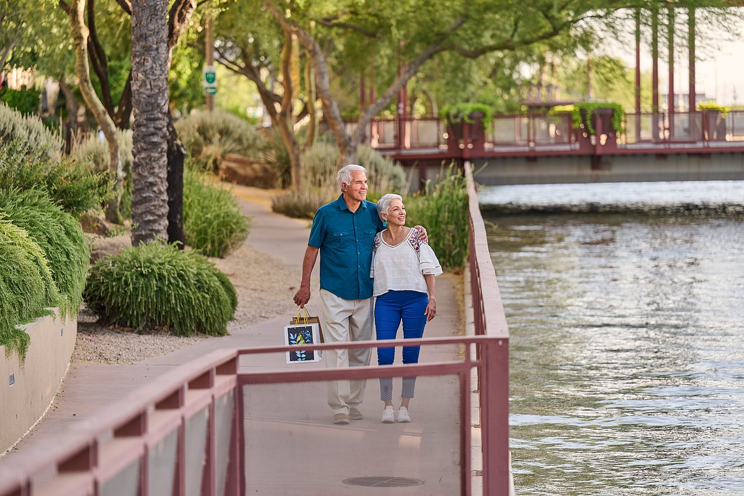 Couple walking along a scenic path by a lake
