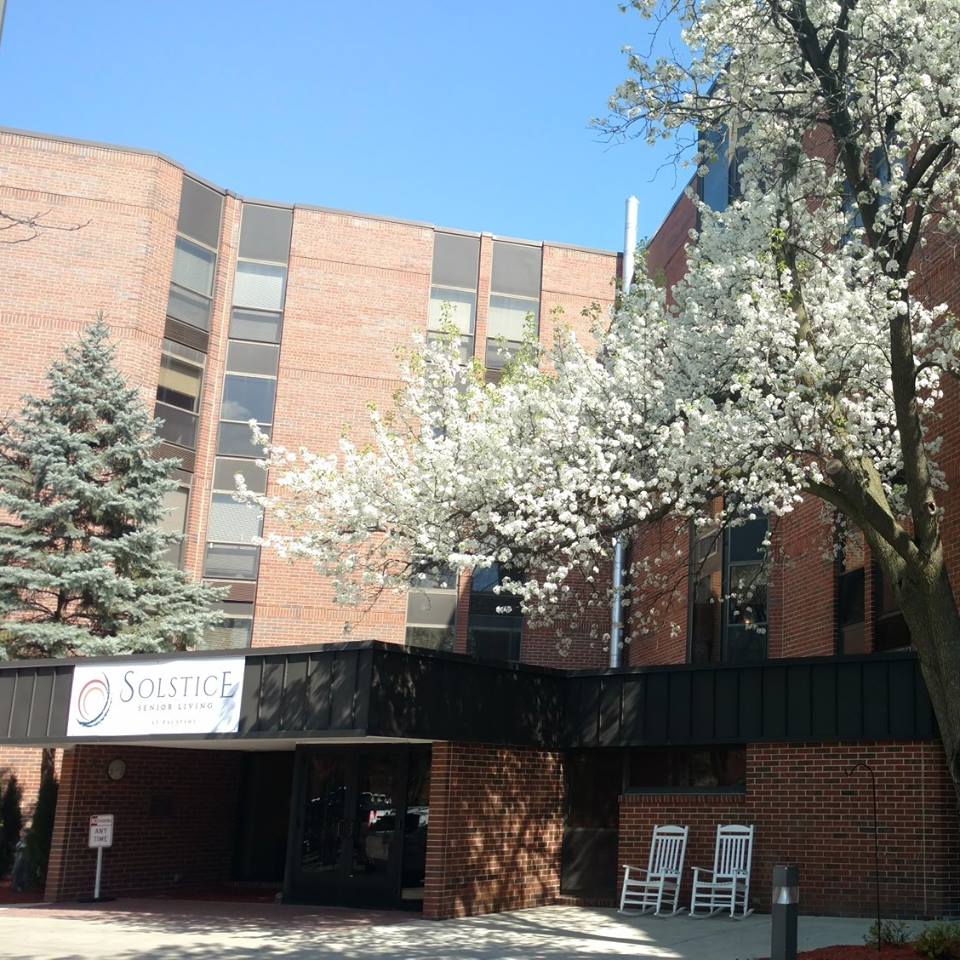Exterior view of Solstice Senior Living building with flowering trees