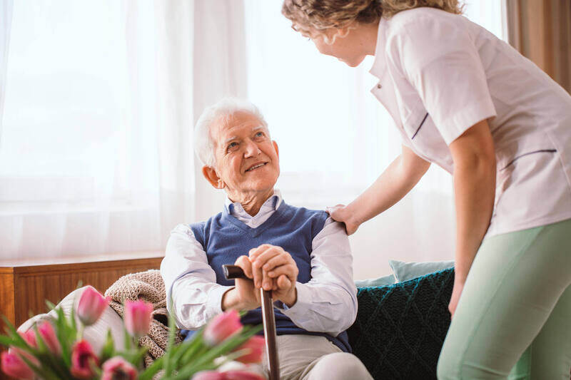 Staff assisting a resident in a cozy living room