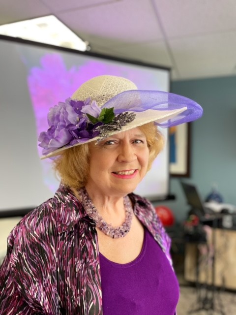 A resident wearing a hat at an event in the activity room