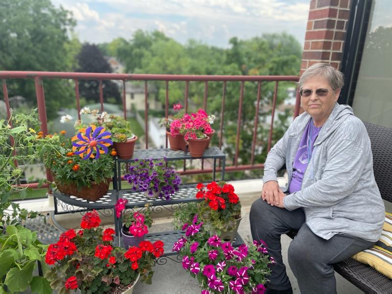 Resident enjoying flowers on a balcony terrace