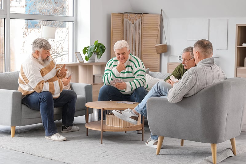 Group of residents playing cards in a cozy lounge
