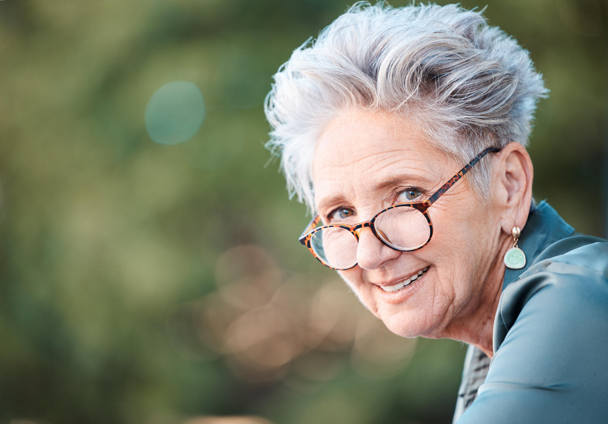 Smiling senior woman with glasses outdoors