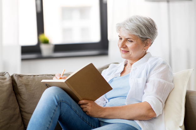 Senior woman writing in a notebook indoors