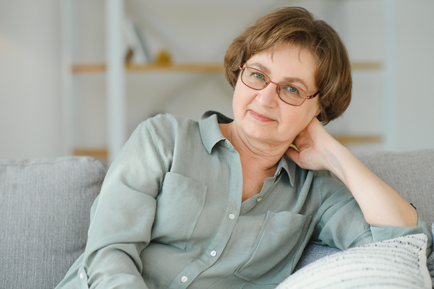 A senior woman relaxing on a couch in a bright interior