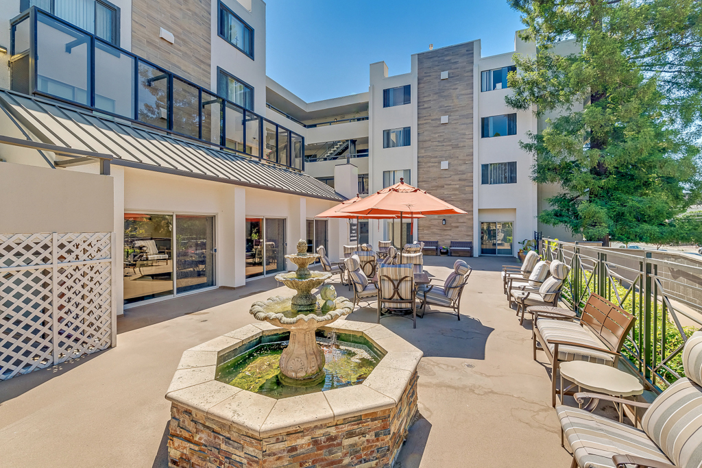 Outdoor seating area with a fountain and building in the background
