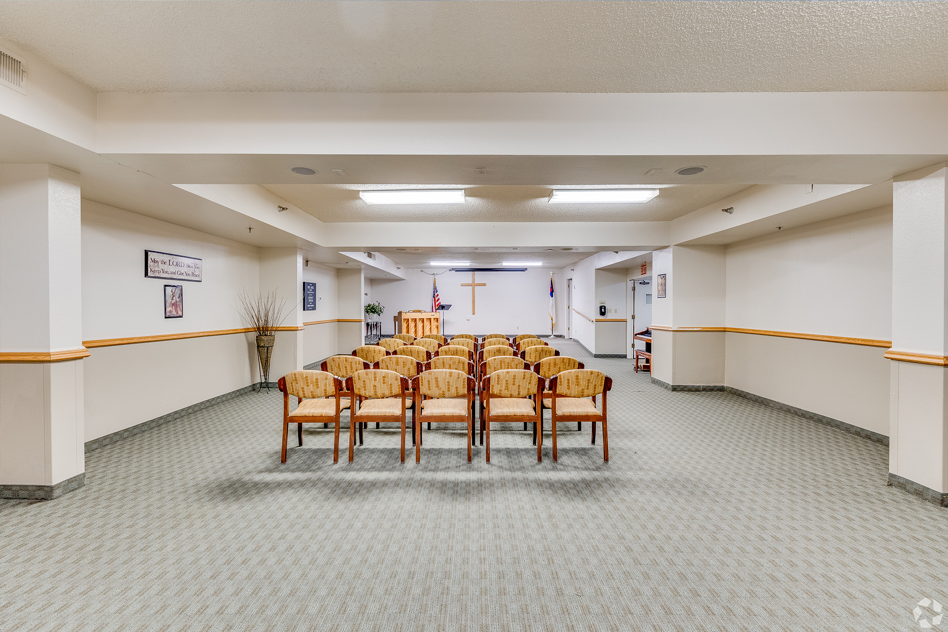 Bright common area with seating and a cross.
