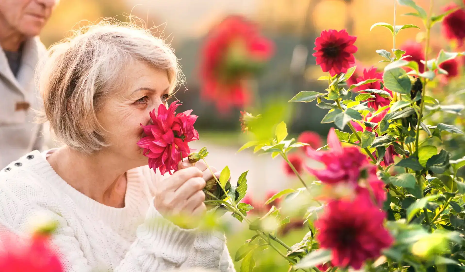 Resident smelling flowers in a garden