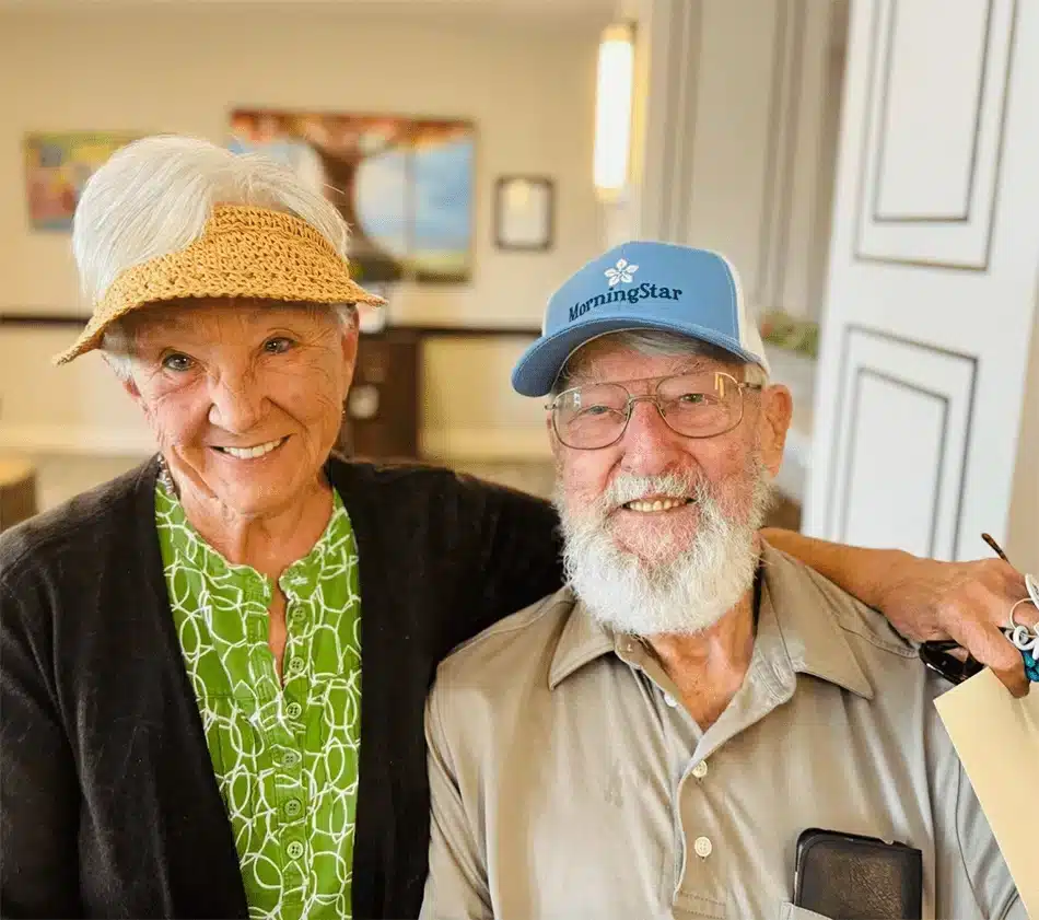 Two smiling residents posing together in a common area