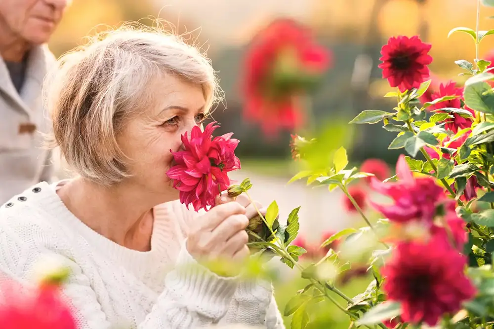 Resident smelling flowers in a garden