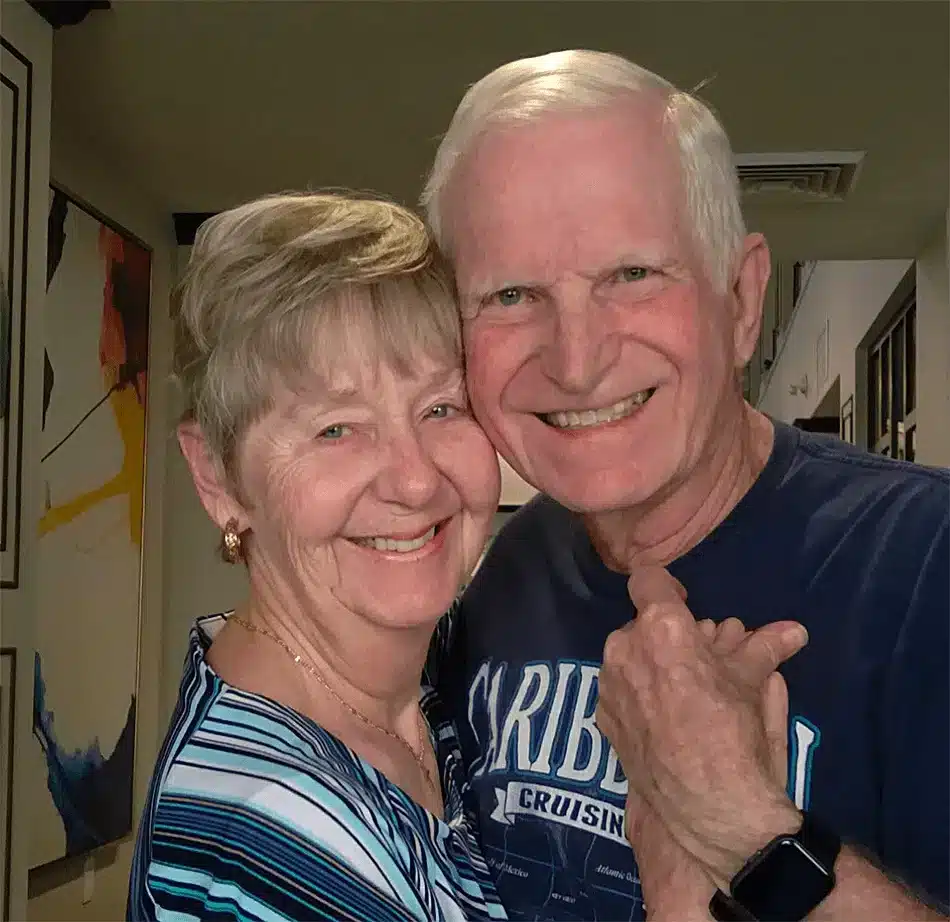 A happy couple posing in a senior living facility corridor