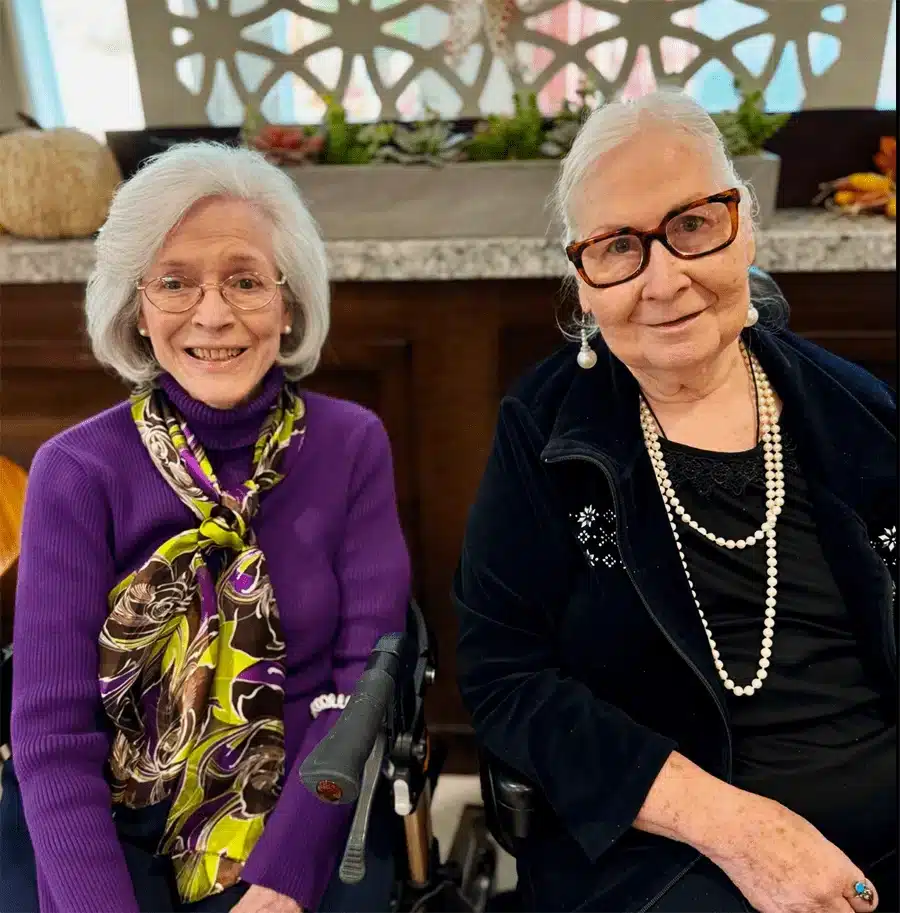 Two residents smiling together in a common area