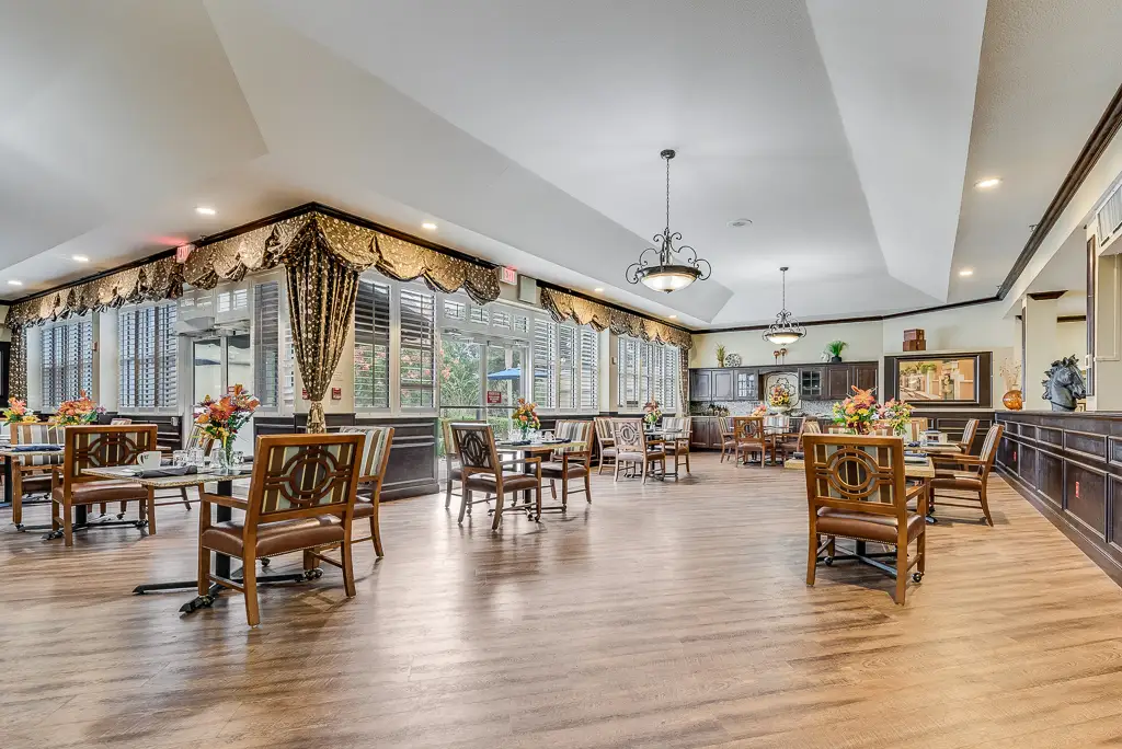 Bright dining room with large windows and floral arrangements