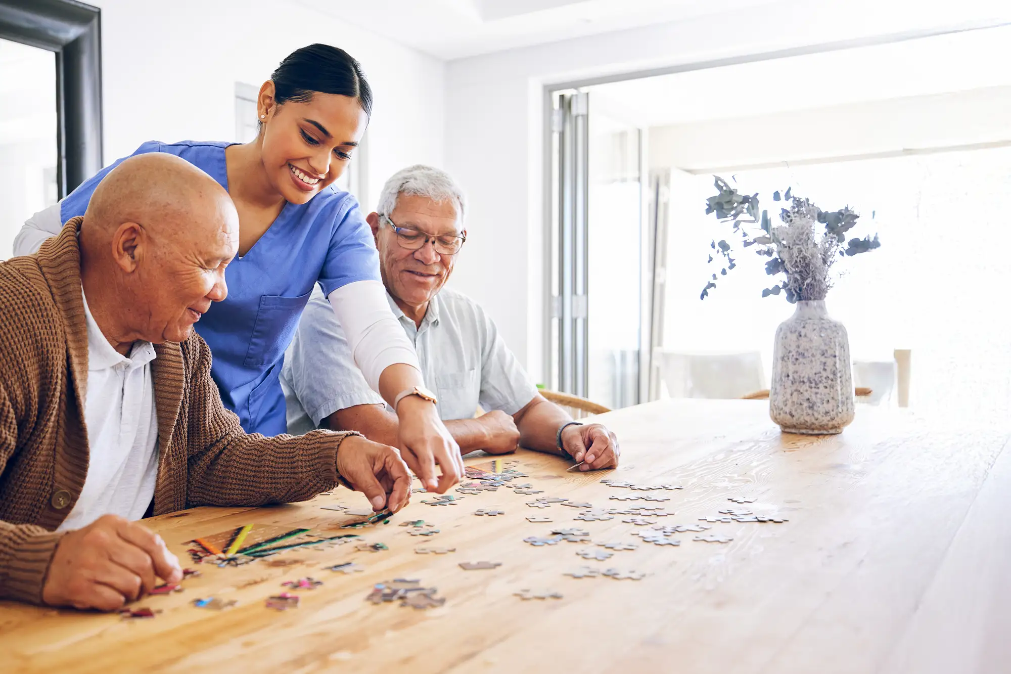 Residents engaging in a puzzle activity with staff assistance
