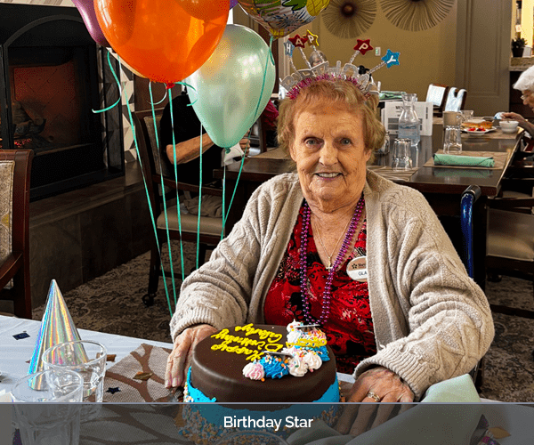 Resident celebrating birthday with cake and balloons