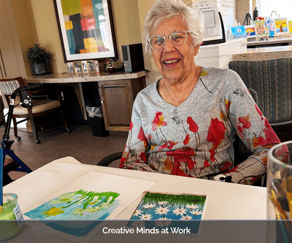 Resident painting in a bright activity room