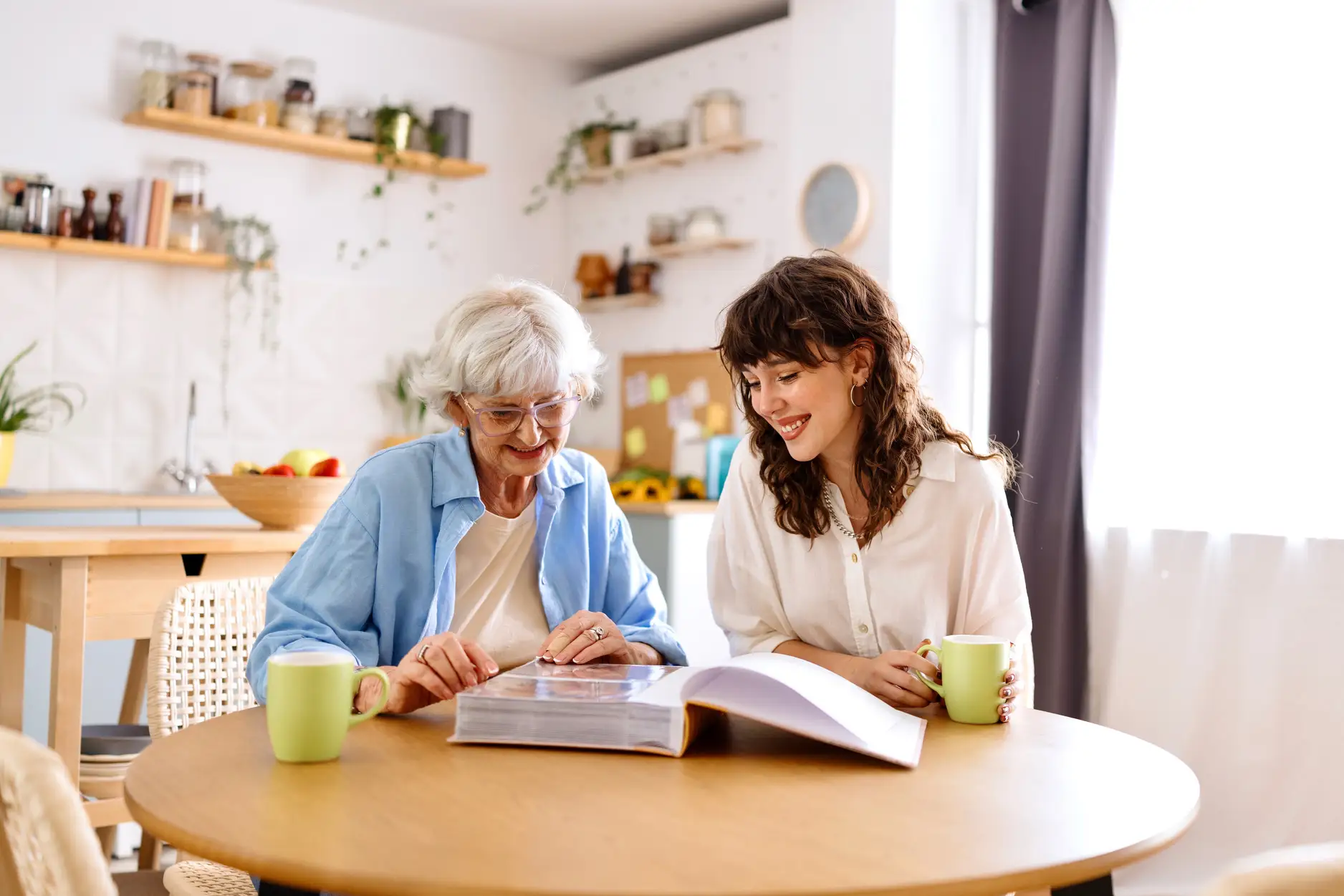Two women at a table looking at a photo album