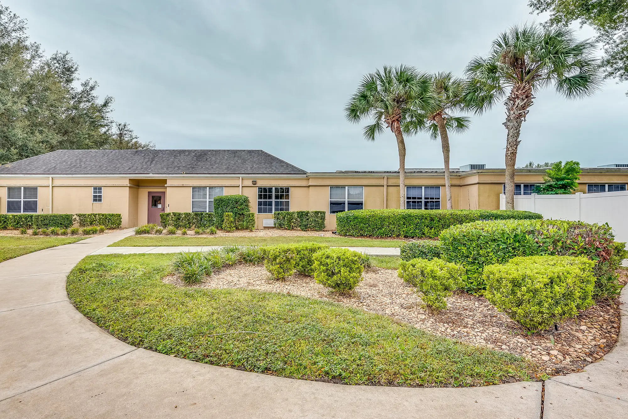 Outdoor pathway with landscaped gardens and palm trees