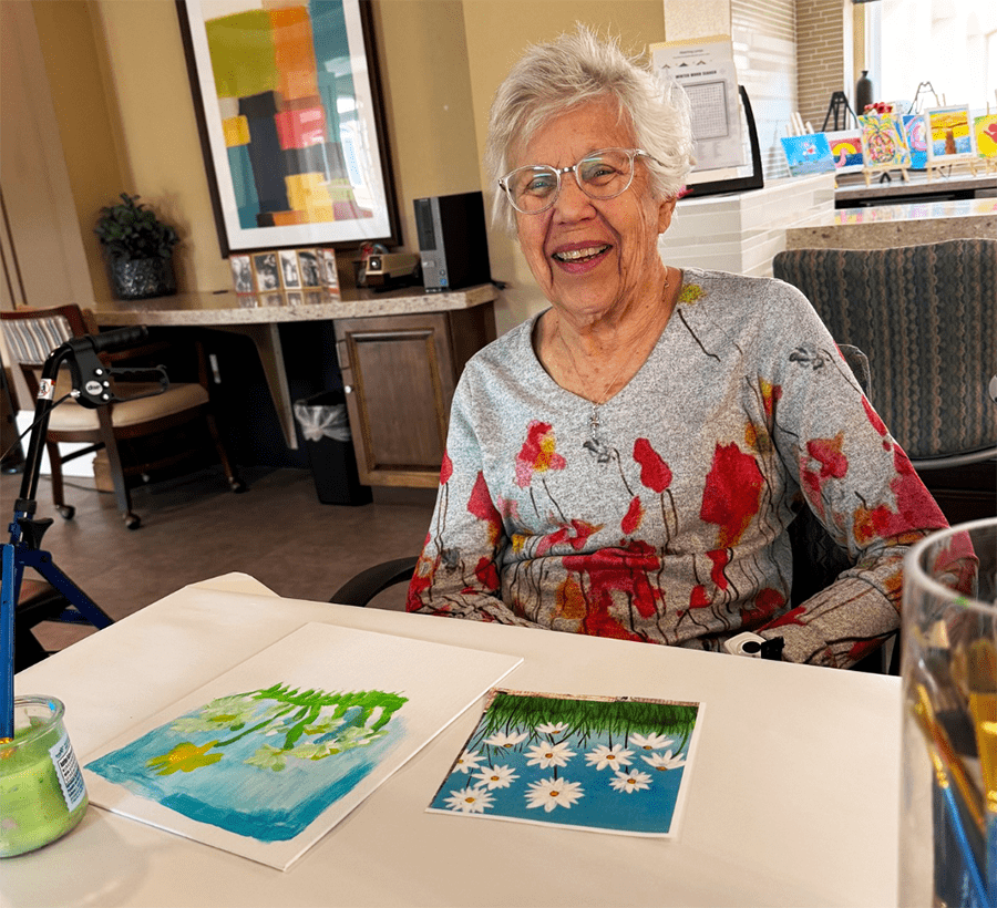 Resident engaging in an art activity with paintings.