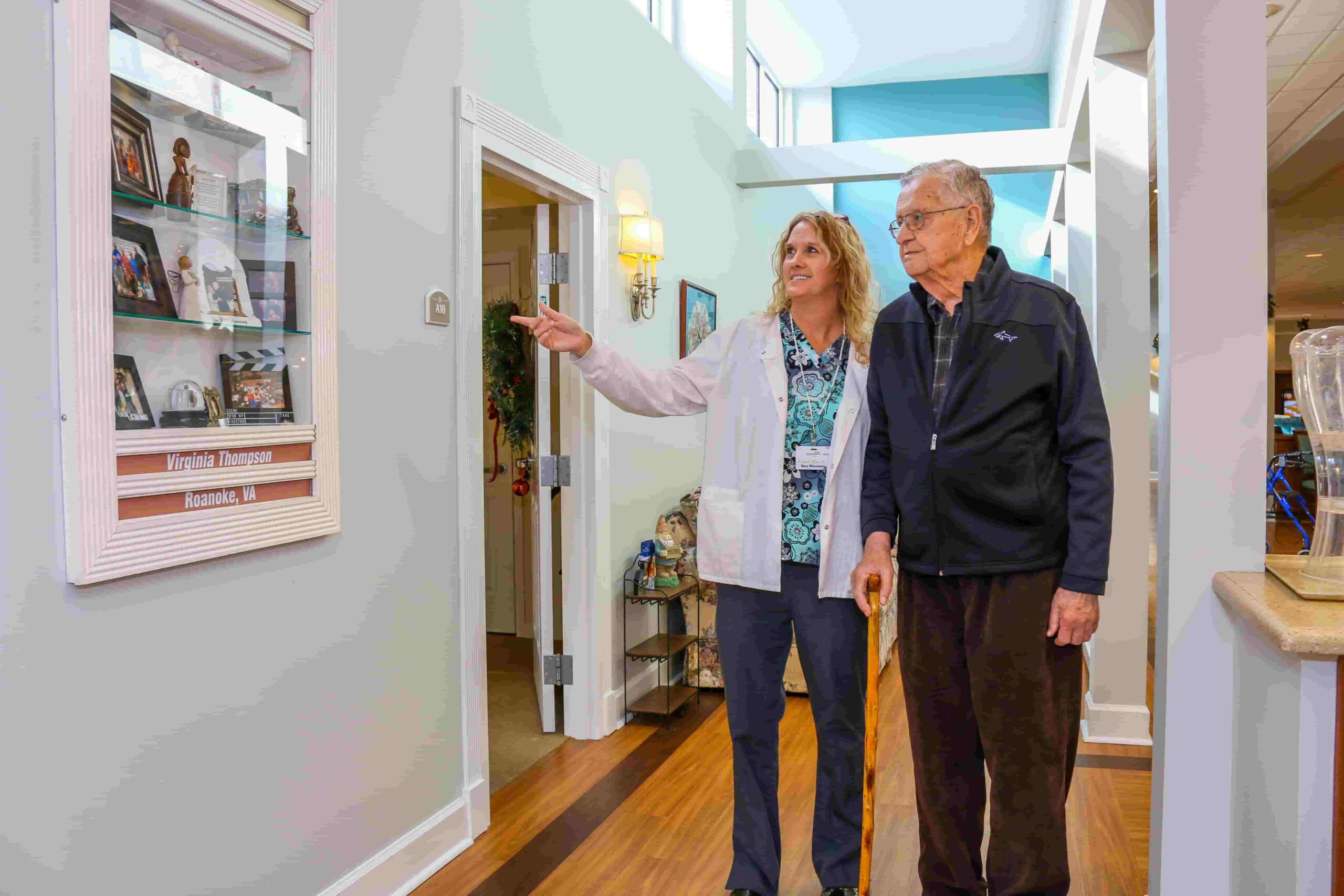 Staff member assisting a resident in a hallway