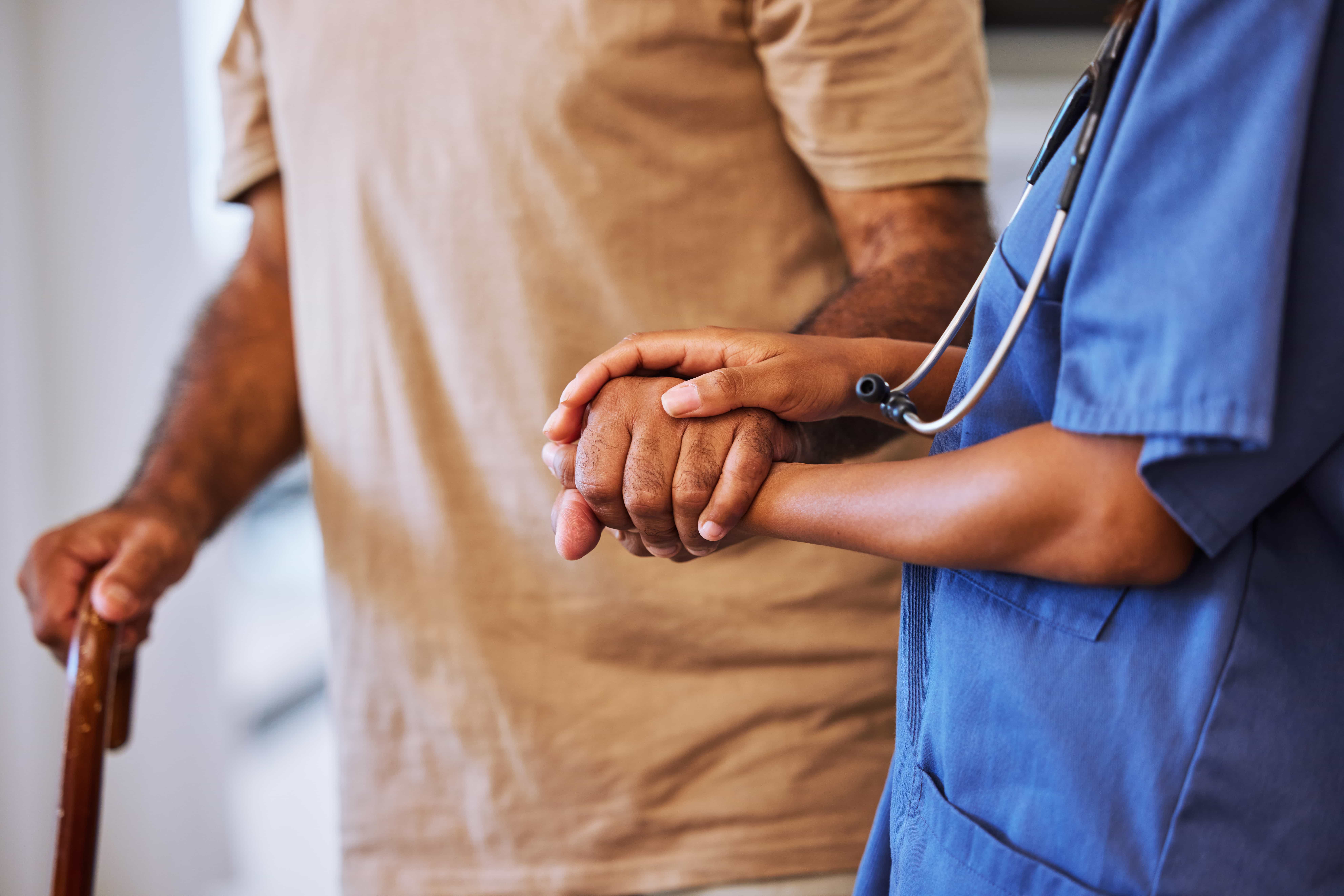 A caregiver holding hands with a resident in a supportive moment