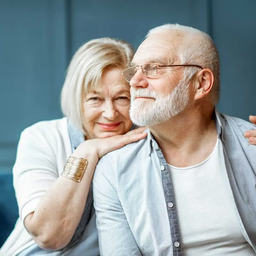 An elderly couple smiling together indoors
