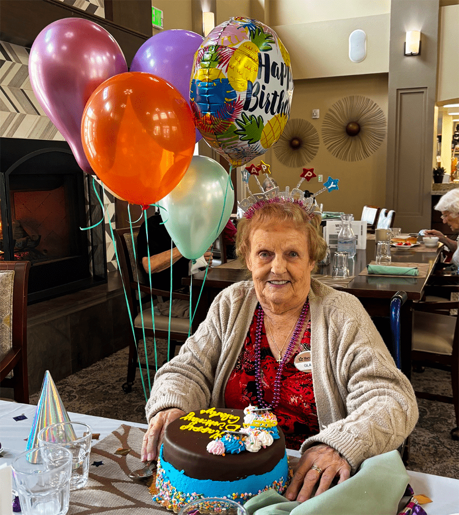 A resident celebrating a birthday with a cake and balloons