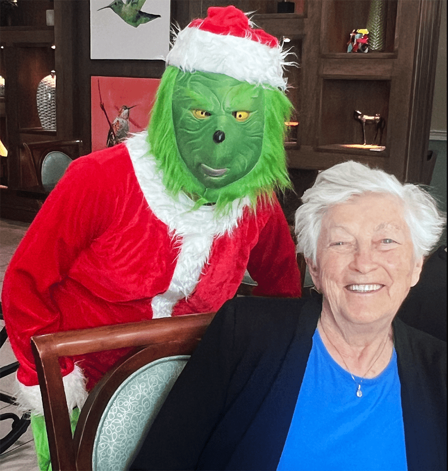 Resident smiling with festive Grinch character
