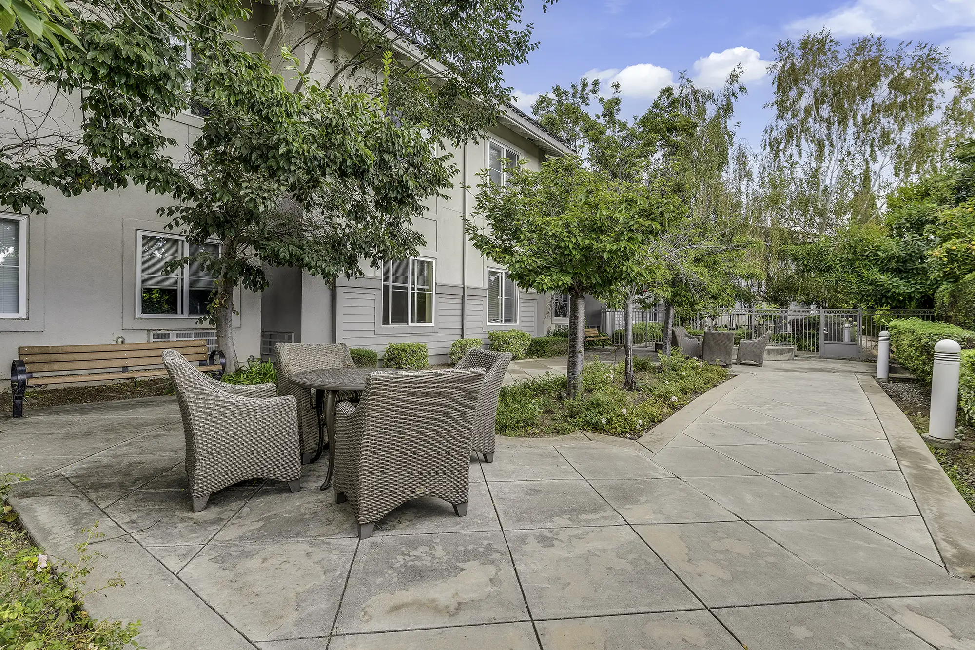 Outdoor seating area with tables and greenery
